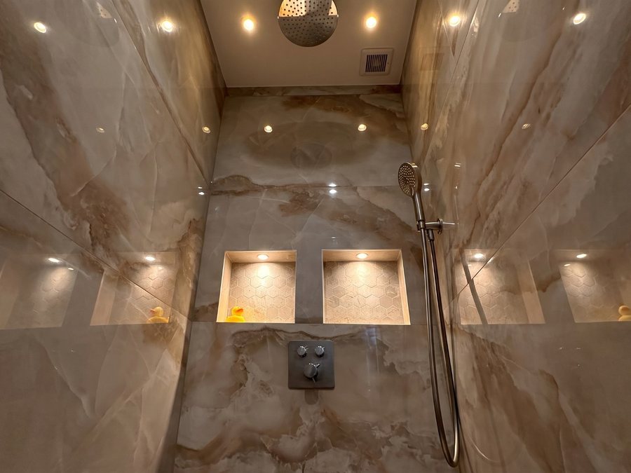 Inloopdouche met verlichte nissen en regendouche in onyx-look tegels